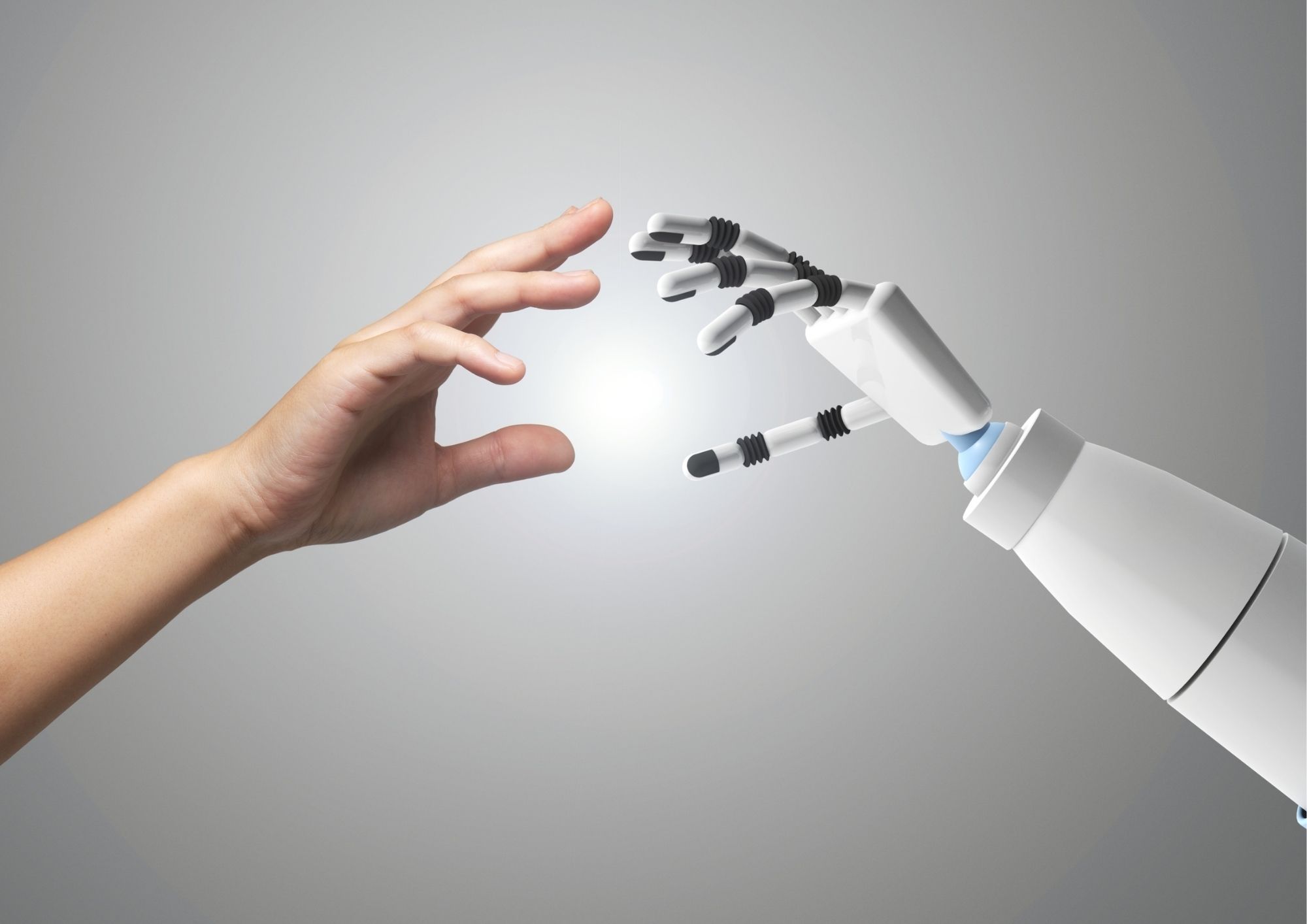 a human hand and robotic hand almost touch